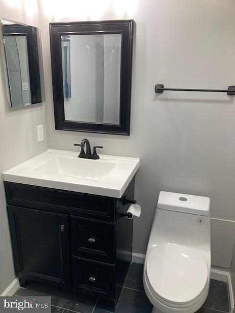 9831 Endora Ct, Owings Mills, MD 21117 - half bath featuring vanity, toilet, baseboards, and tile patterned floors