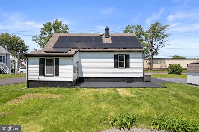 1224 W Mill St, Quakertown, PA 18951 - back of property with a yard, roof with shingles, roof mounted solar panels, and central air condition unit