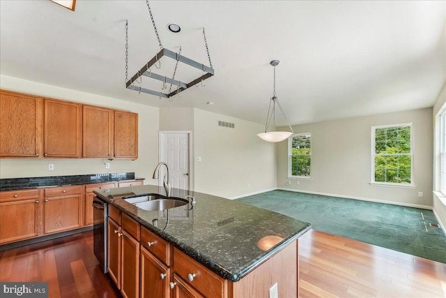 916 E Fox Hound Chase Chase, Glen Mills, PA 19342 - kitchen featuring a sink, dishwasher, dark wood-style flooring, dark stone countertops, and an island with sink