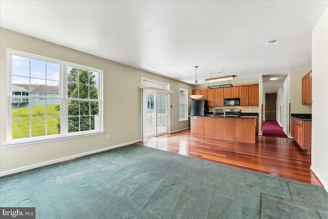 916 E Fox Hound Chase Chase, Glen Mills, PA 19342 - unfurnished living room featuring dark colored carpet, baseboards, and dark wood-style flooring