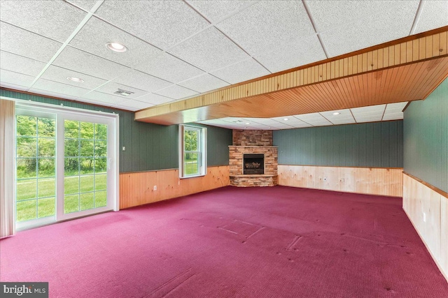 916 E Fox Hound Chase Chase, Glen Mills, PA 19342 - unfurnished living room with wood walls, carpet floors, a stone fireplace, plenty of natural light, and wainscoting