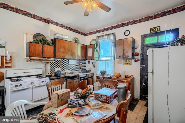 505 N Schroeder St, Baltimore, MD 21223 - kitchen featuring white appliances, ceiling fan, brown cabinets, backsplash, and under cabinet range hood