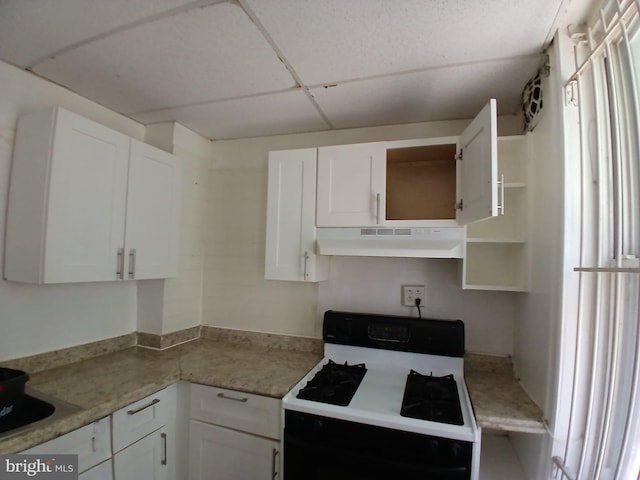 2926 N Stillman St, Philadelphia, PA 19132 - kitchen with under cabinet range hood, gas range, open shelves, and white cabinetry