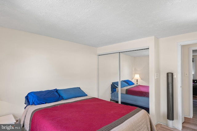 7627 Fallswood Way, Lorton, VA 22079 - bedroom featuring wood finished floors, a closet, and a textured ceiling