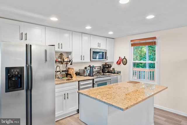 7627 Fallswood Way, Lorton, VA 22079 - kitchen with stainless steel appliances, light wood-type flooring, a center island, white cabinetry, and recessed lighting