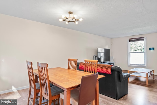 7627 Fallswood Way, Lorton, VA 22079 - dining area with a chandelier, light wood-style flooring, and a textured ceiling