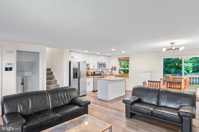 7627 Fallswood Way, Lorton, VA 22079 - living room with stairs, a chandelier, light wood-type flooring, recessed lighting, and a textured ceiling