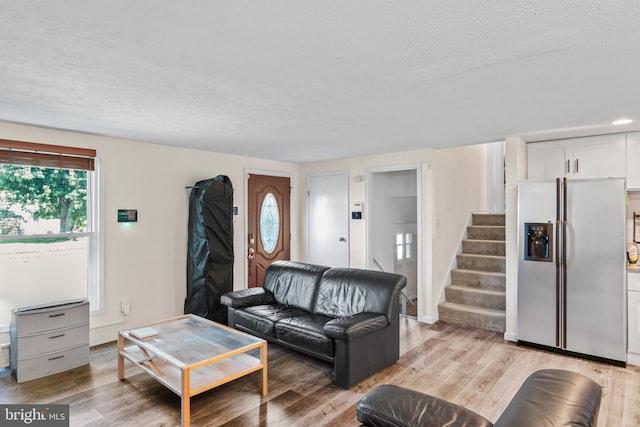 7627 Fallswood Way, Lorton, VA 22079 - living area featuring stairs, light wood-style flooring, and a textured ceiling