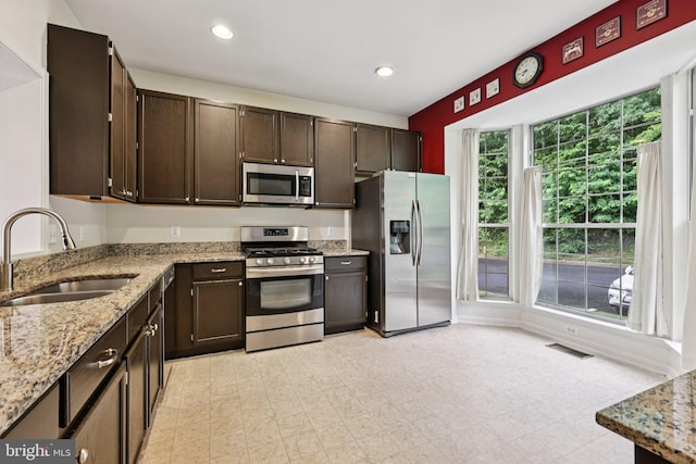 11793 Nates Pl, Woodbridge, VA 22192 - kitchen featuring stainless steel appliances, dark brown cabinetry, light stone countertops, and recessed lighting