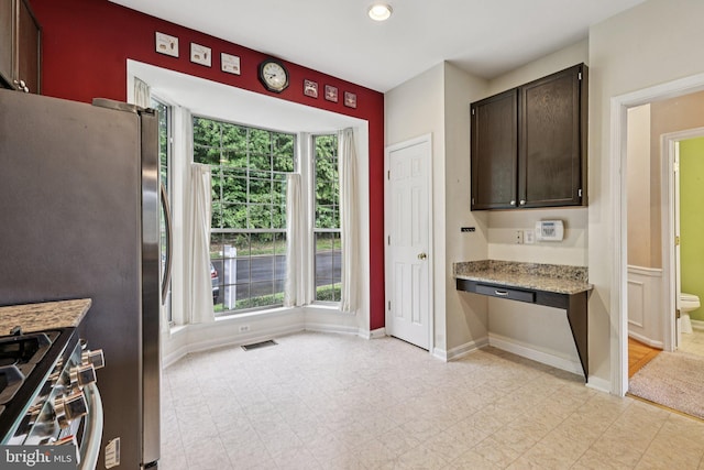 11793 Nates Pl, Woodbridge, VA 22192 - kitchen with stainless steel gas stove, dark brown cabinets, light stone countertops, and recessed lighting