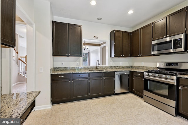 11793 Nates Pl, Woodbridge, VA 22192 - kitchen with appliances with stainless steel finishes, light stone counters, dark brown cabinetry, and recessed lighting