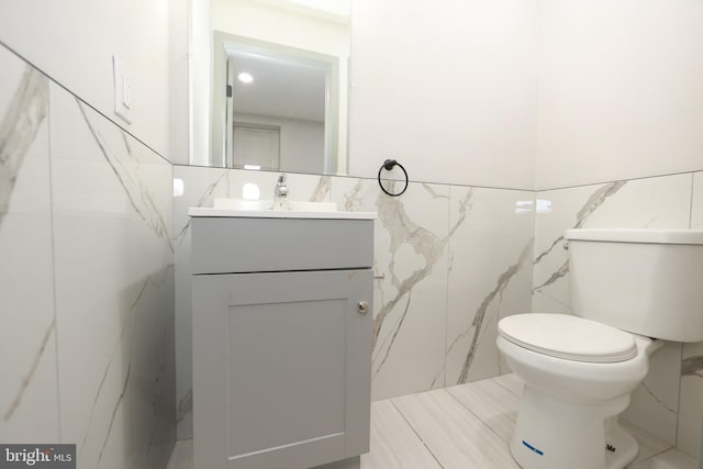 1357 E Sedgley Ave, Philadelphia, PA 19134 - bathroom featuring tile walls, vanity, toilet, and a wainscoted wall