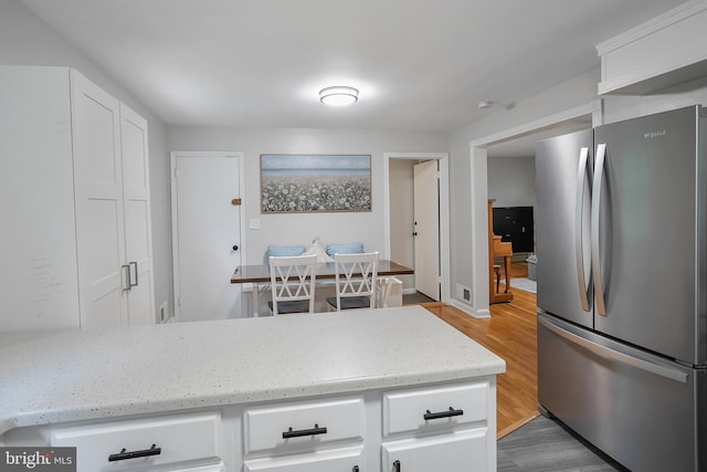 6001 Kroy Ct, Springfield, VA 22150 - kitchen with freestanding refrigerator, white cabinets, light wood-style floors, and light stone counters