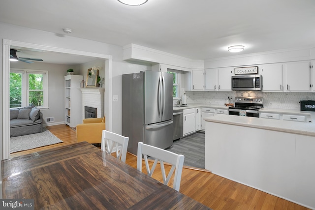 6001 Kroy Ct, Springfield, VA 22150 - kitchen featuring appliances with stainless steel finishes, light countertops, wood finished floors, and white cabinets