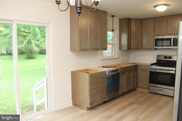 803 Grafton St, Fredericksburg, VA 22405 - kitchen featuring appliances with stainless steel finishes, light wood-style flooring, a chandelier, and decorative light fixtures