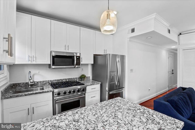 1832 Calvert St NW Unit 3, Washington, DC 20009 - kitchen featuring appliances with stainless steel finishes, a sink, white cabinets, light stone countertops, and crown molding
