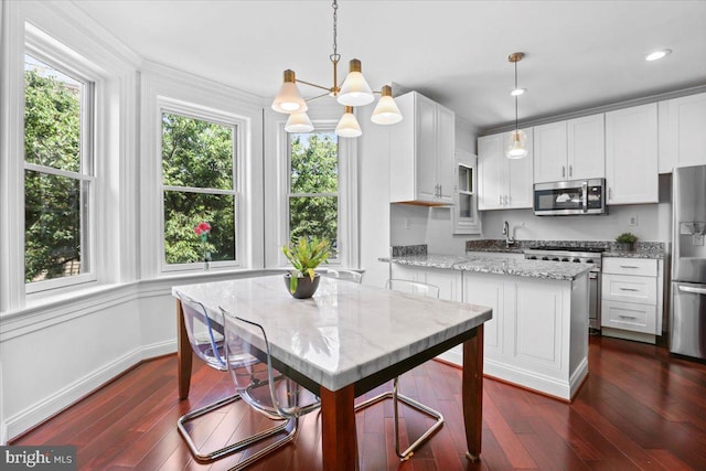 1832 Calvert St NW Unit 3, Washington, DC 20009 - kitchen with appliances with stainless steel finishes, white cabinetry, dark wood-style flooring, a chandelier, and recessed lighting
