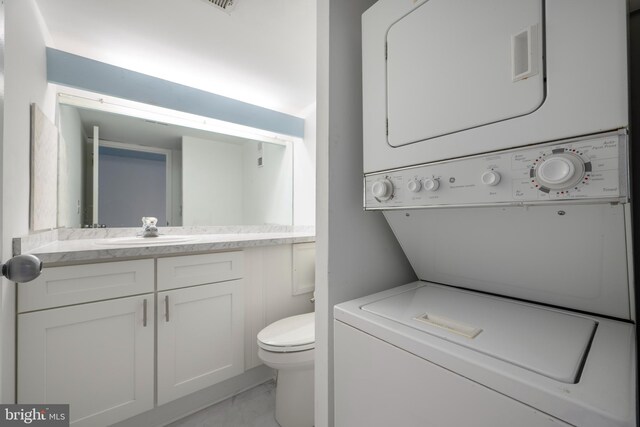 9500 Coastal Hwy Unit 1L, Ocean City, MD 21842 - bathroom with stacked washer / drying machine, vanity, toilet, and marble look tile flooring