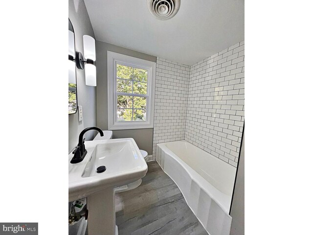 1045 S Bradford St, Dover, DE 19904 - full bathroom featuring wood finished floors, a bathtub, and a shower