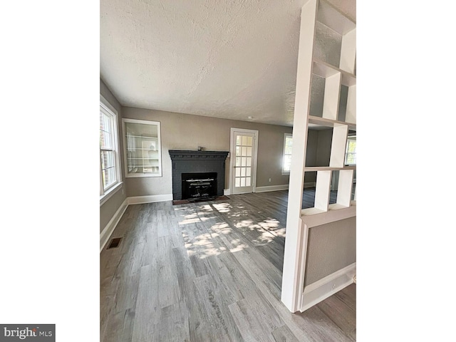 1045 S Bradford St, Dover, DE 19904 - unfurnished living room with a textured ceiling, wood finished floors, and a fireplace