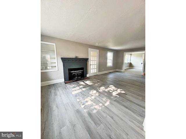 1045 S Bradford St, Dover, DE 19904 - unfurnished living room with wood finished floors, a textured ceiling, and a fireplace