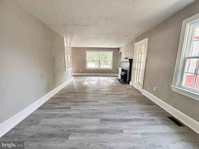 1045 S Bradford St, Dover, DE 19904 - unfurnished living room with wood finished floors, a fireplace, and a textured ceiling