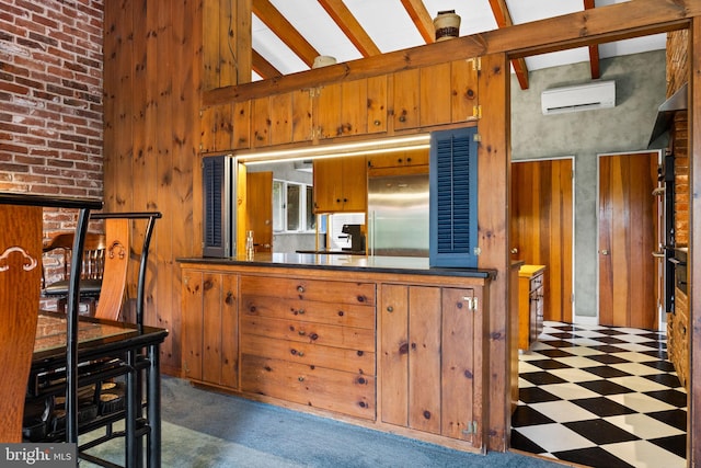 320 S Main St, Quakertown, PA 18951 - kitchen featuring an AC wall unit, built in fridge, tile patterned floors, wooden walls, and brown cabinets