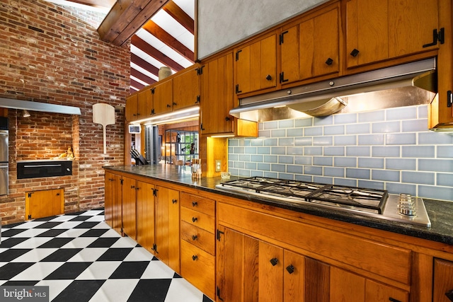 320 S Main St, Quakertown, PA 18951 - kitchen featuring light floors, stainless steel gas stovetop, dark countertops, brown cabinets, and under cabinet range hood