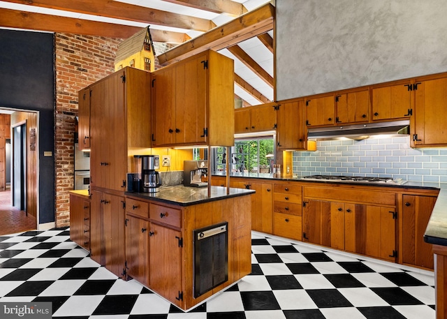 320 S Main St, Quakertown, PA 18951 - kitchen featuring light floors, under cabinet range hood, stainless steel gas cooktop, dark countertops, and brown cabinetry