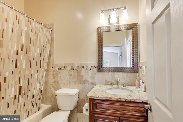 3603 John Ct, Annandale, VA 22003 - bathroom with toilet, vanity, tile walls, shower / bath combo with shower curtain, and a wainscoted wall