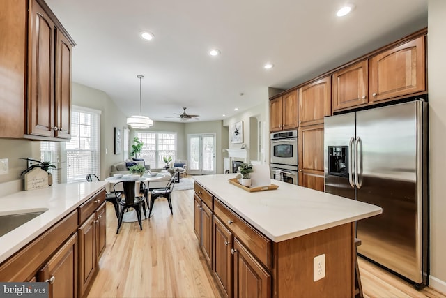 2177 S Glebe Rd, Arlington, VA 22204 - kitchen with appliances with stainless steel finishes, open floor plan, light wood-style flooring, brown cabinetry, and recessed lighting