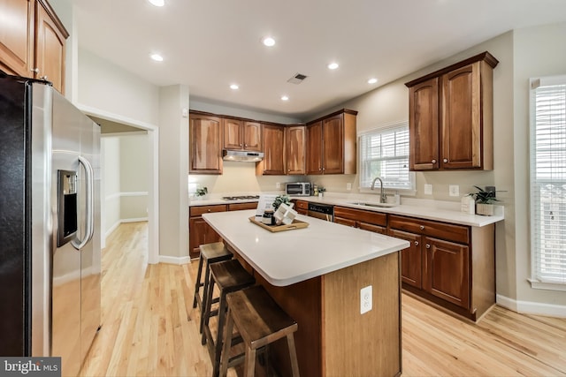 2177 S Glebe Rd, Arlington, VA 22204 - kitchen with stainless steel appliances, under cabinet range hood, a sink, light wood-style flooring, and recessed lighting
