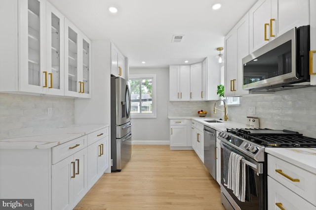 418 Belton Ct, Silver Spring, MD 20901 - kitchen with appliances with stainless steel finishes, white cabinetry, light stone counters, light wood-style flooring, and recessed lighting