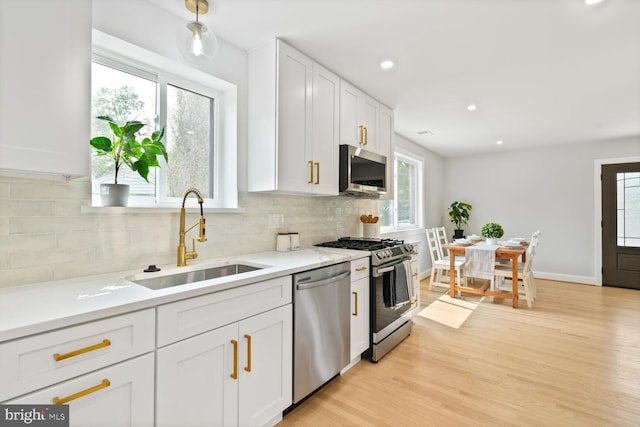418 Belton Ct, Silver Spring, MD 20901 - kitchen with stainless steel appliances, a sink, white cabinets, decorative backsplash, and light countertops