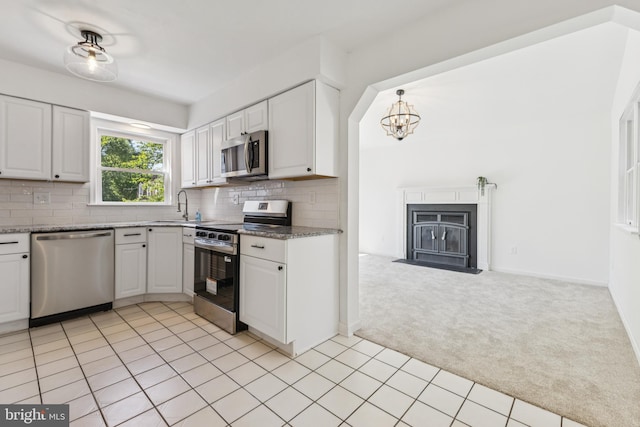 6248 Light Point Pl, Columbia, MD 21045 - kitchen featuring stainless steel appliances, light colored carpet, decorative backsplash, white cabinetry, and a chandelier