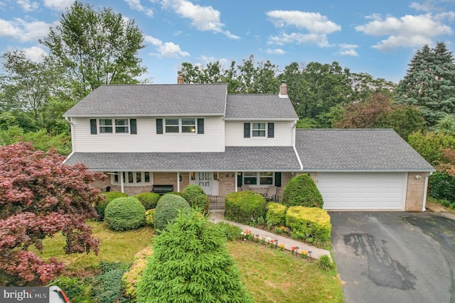 44 Creek Rd, Newville, PA 17241 - traditional-style house featuring a chimney, a porch, a garage, brick siding, and asphalt driveway