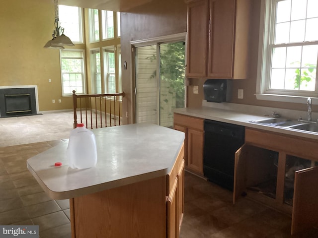 8207 Rison Dr, Brandywine, MD 20613 - kitchen featuring black dishwasher, a sink, light countertops, a glass covered fireplace, and a center island