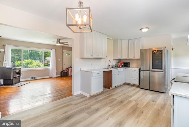 1503 Shirley Ave, Carlisle, PA 17013 - kitchen with smart refrigerator, light countertops, light wood-style floors, a wood stove, and ceiling fan