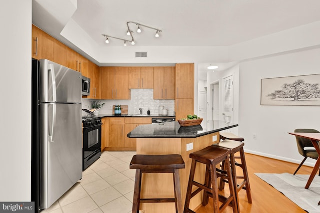 1021 N Garfield St Unit B37, Arlington, VA 22201 - kitchen featuring stainless steel appliances, a sink, a kitchen breakfast bar, tasteful backsplash, and a kitchen island