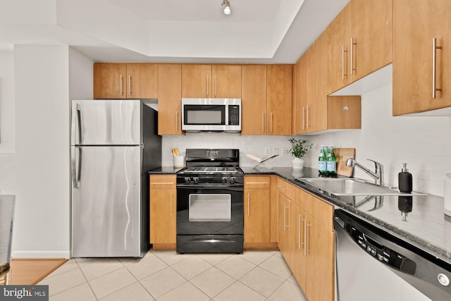 1021 N Garfield St Unit B37, Arlington, VA 22201 - kitchen featuring appliances with stainless steel finishes, a sink, a tray ceiling, dark stone counters, and light tile patterned floors