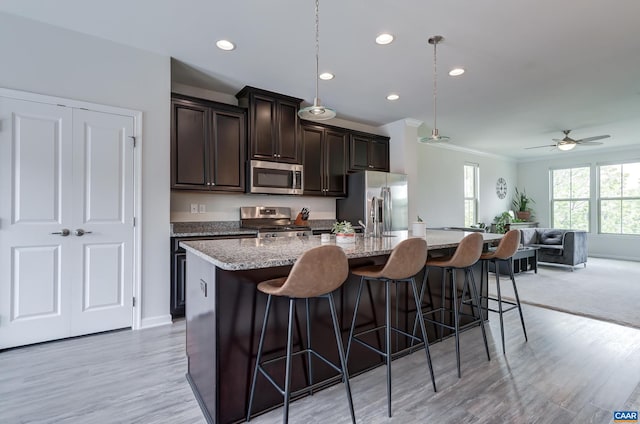 905 Flat Waters Ln, Charlottesville, VA 22911 - kitchen with stainless steel appliances, a center island with sink, a breakfast bar, dark brown cabinets, and ornamental molding