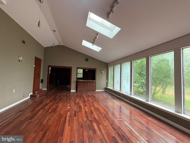 790 Hopewell Rd, Downingtown, PA 19335 - unfurnished living room featuring a skylight, wood finished floors, vaulted ceiling, rail lighting, and baseboards