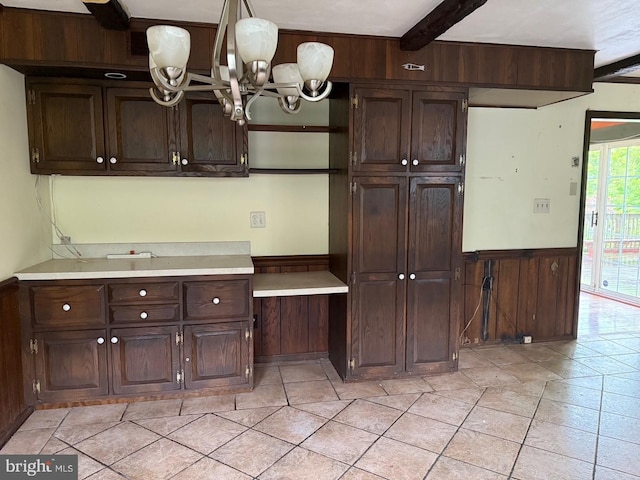 790 Hopewell Rd, Downingtown, PA 19335 - kitchen with a chandelier, light countertops, dark brown cabinetry, a wainscoted wall, and beam ceiling