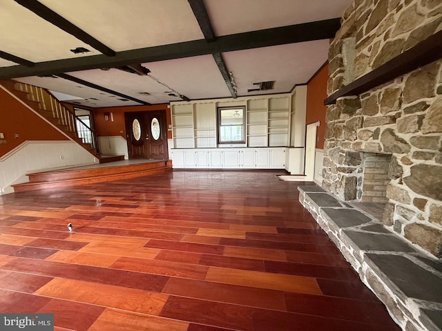 790 Hopewell Rd, Downingtown, PA 19335 - unfurnished living room featuring wood finished floors, beamed ceiling, a wainscoted wall, stairway, and a decorative wall
