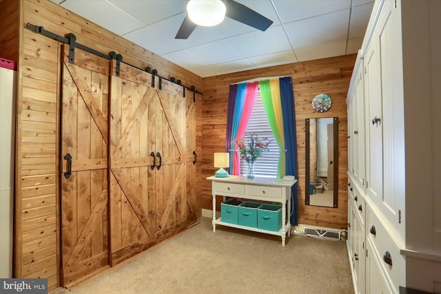 1311 Church St, Lititz, PA 17543 - bedroom with wooden walls, carpet floors, a barn door, and a ceiling fan