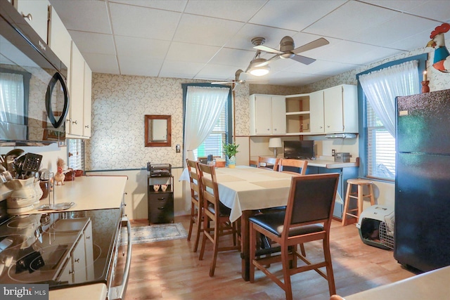 1311 Church St, Lititz, PA 17543 - dining space featuring wallpapered walls, a ceiling fan, light wood finished floors, and a paneled ceiling