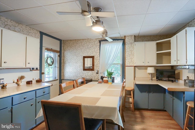 1311 Church St, Lititz, PA 17543 - dining space with wallpapered walls, ceiling fan, light wood-style flooring, and a paneled ceiling