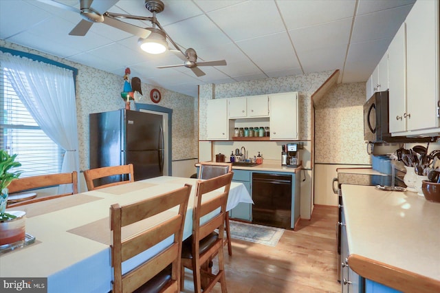 1311 Church St, Lititz, PA 17543 - kitchen featuring wallpapered walls, a ceiling fan, black appliances, white cabinets, and light wood-style floors
