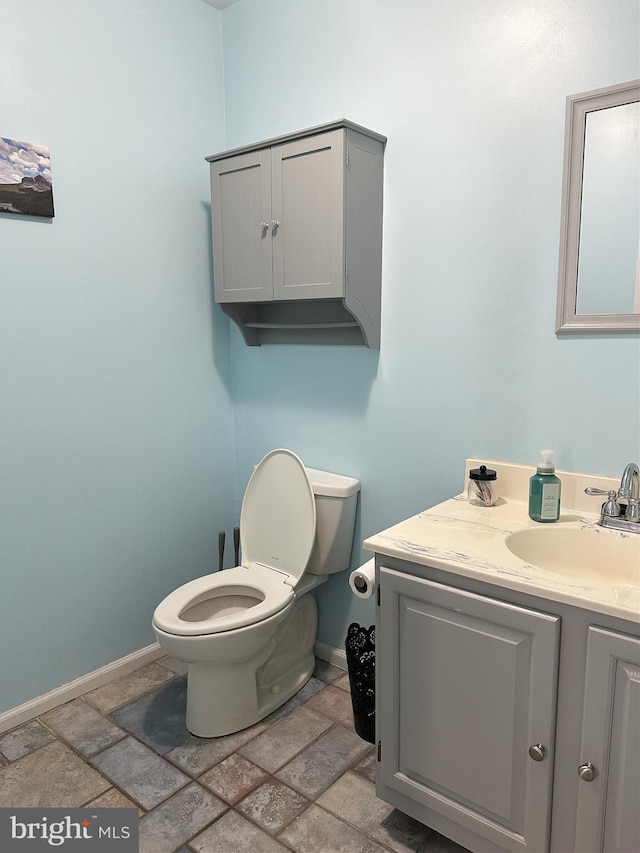 584 Meadow Ln, Pennsburg, PA 18073 - bathroom with vanity, stone tile floors, toilet, and baseboards