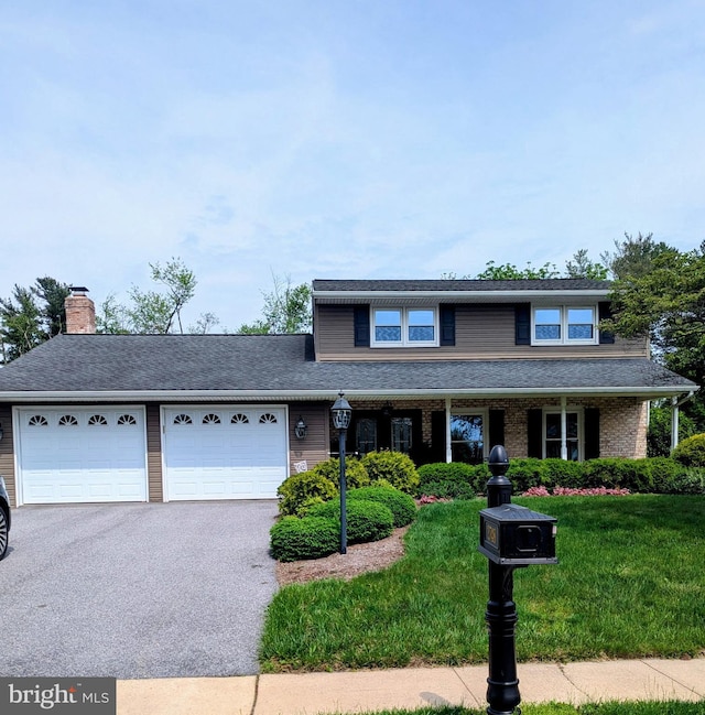 2748 Thornbridge Rd E, York, PA 17408 - traditional home with asphalt driveway, an attached garage, a front lawn, a chimney, and covered porch